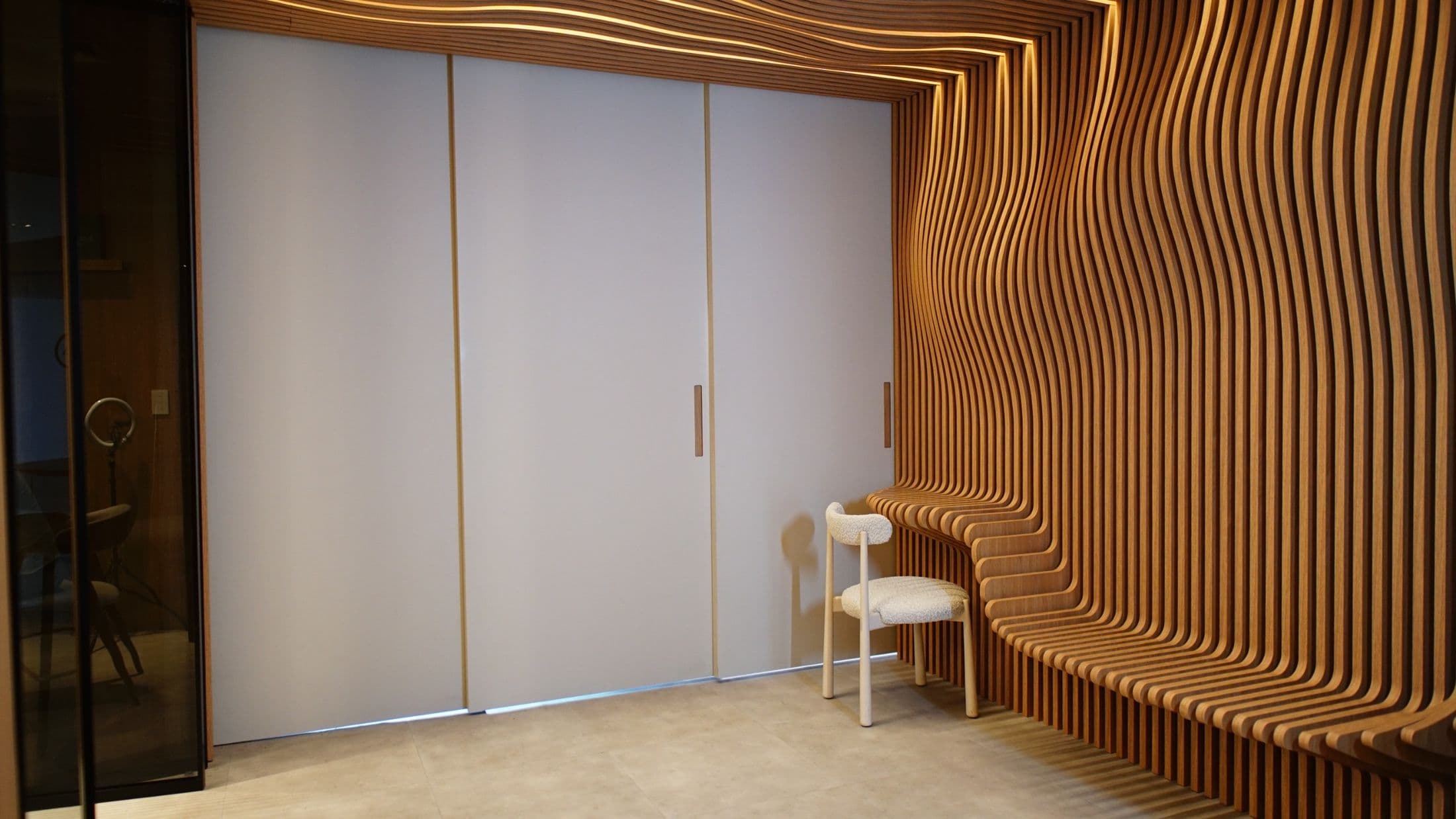 Banco escultural de ripas curvas em madeira no showroom